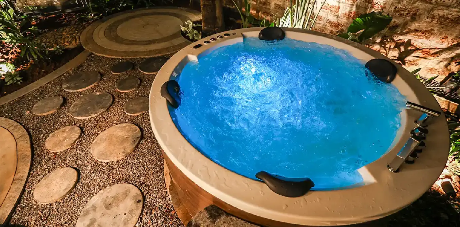 Private outdoor Jacuzzi at Orchid Passaros Goa surrounded by tropical plants and warm lighting