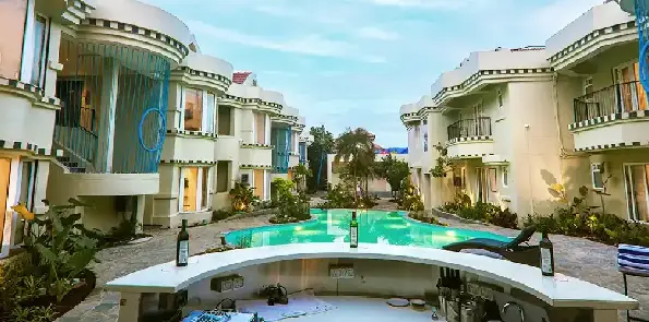 Swimming pool surrounded by resort villas for a romantic stay in South Goa